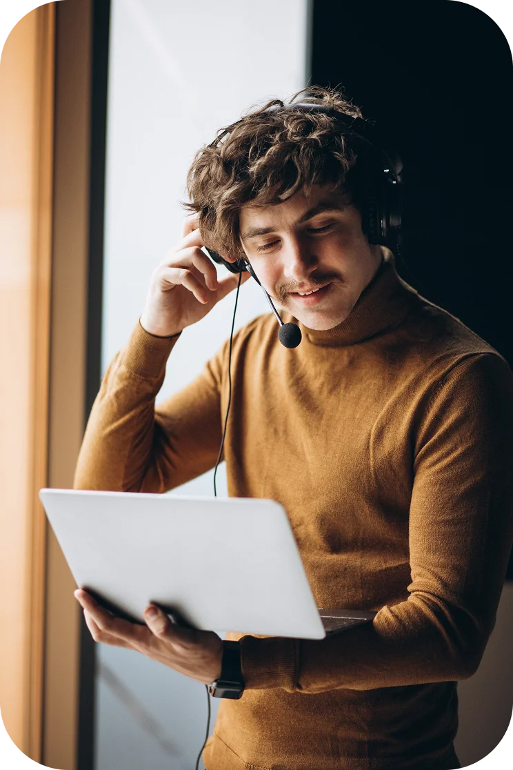 Young male interpreter working on a laptop, related to app maintenance and support.